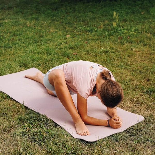 Person stretching gently on a yoga mat in a calm setting.